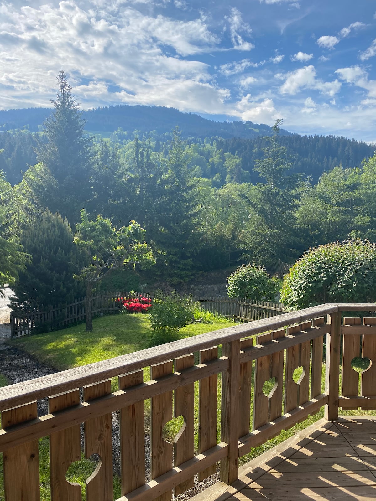 La terrasse aux cœurs en été, jardin fleuri et montagnes vertes