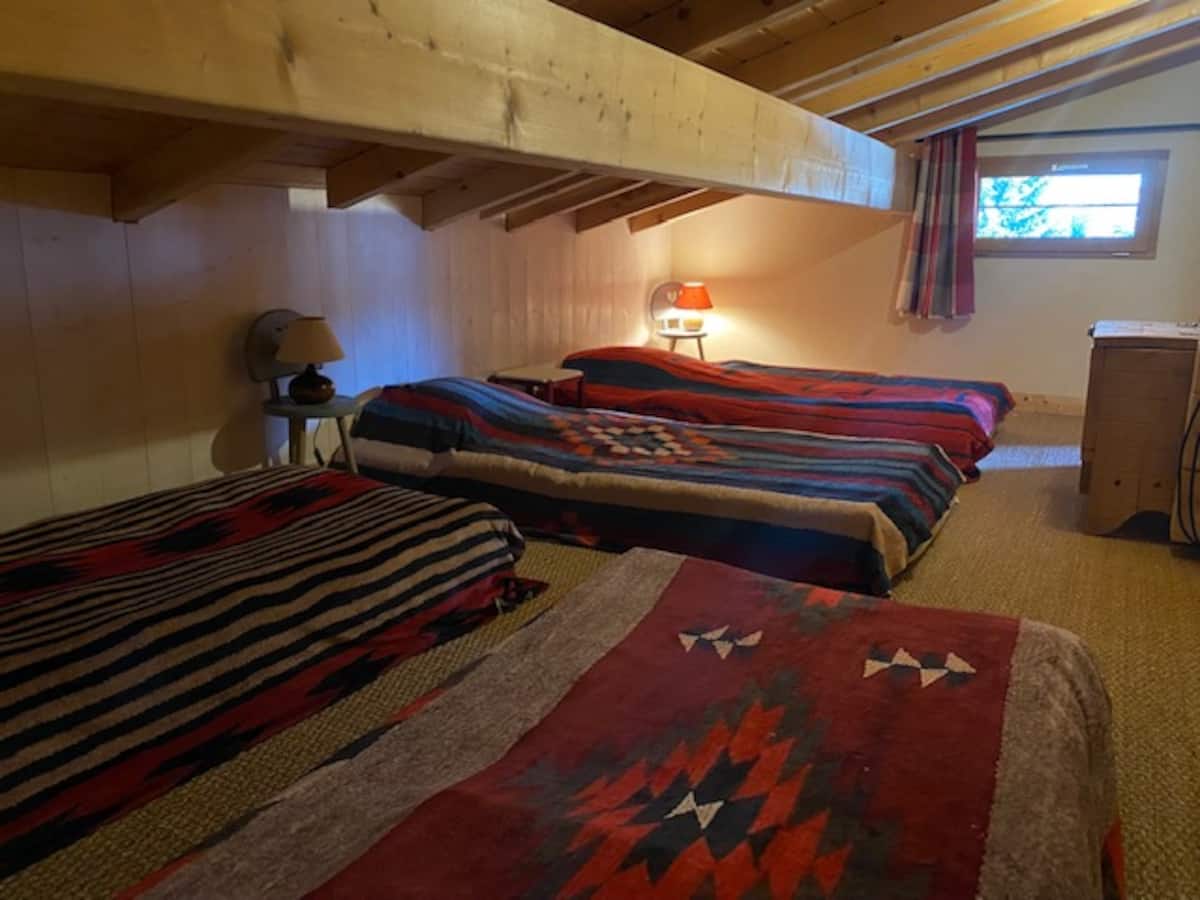 Le dortoir des enfants : quatre couchages, chacun sous le panneau d'un sommet du pays du Mont-Blanc