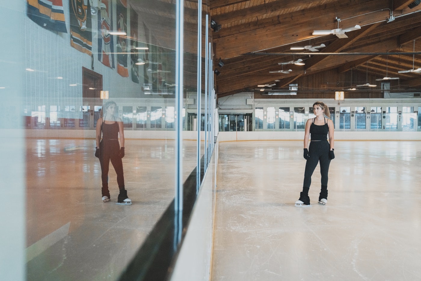 Patineuse sur la glace d'une patinoire couverte à la charpente de bois