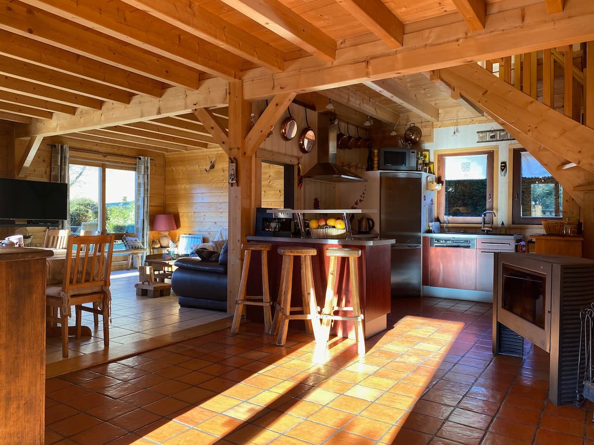 La pièce à vivre de 60 m² baignée de soleil : cuisine, salon et poutres en bois